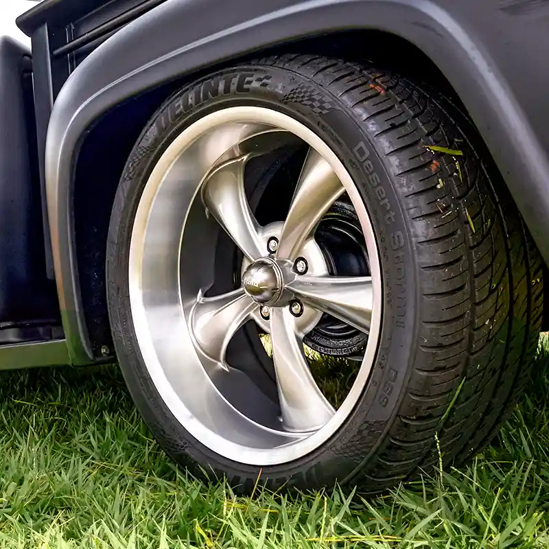 Close-up of a red car's tire and custom gray wheel. Automotive tires and rims.
