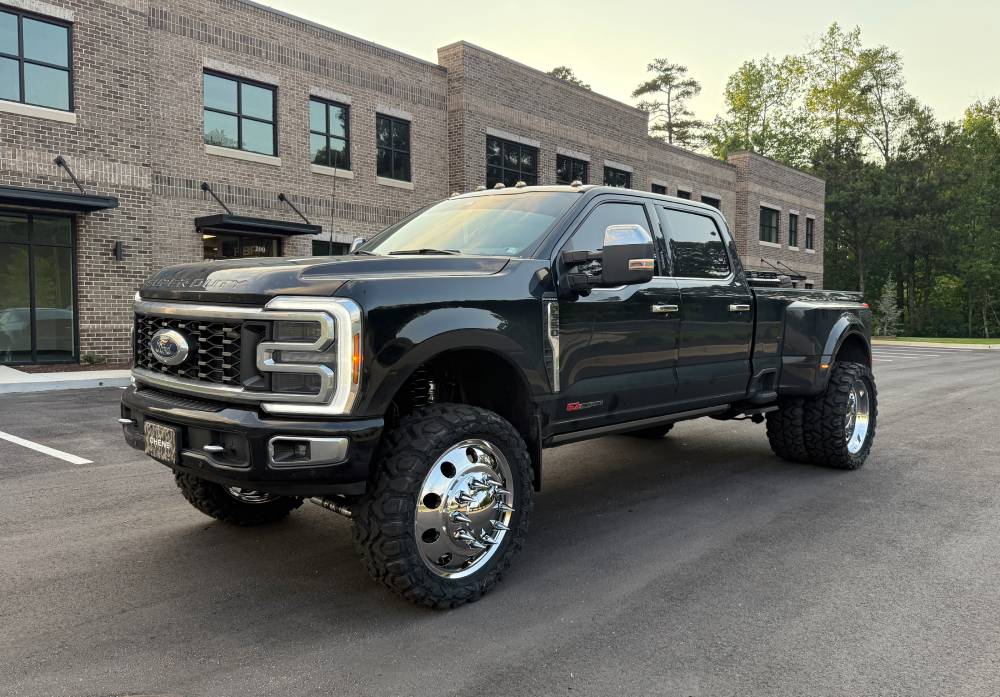 Black lifted Ford Super Duty dually with chrome wheels by brick office—Automotive Expressions custom lift kit, wheel package
